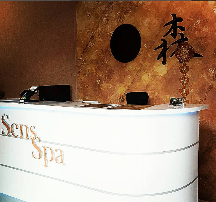 Sens Spa reception desk with warm marble wall